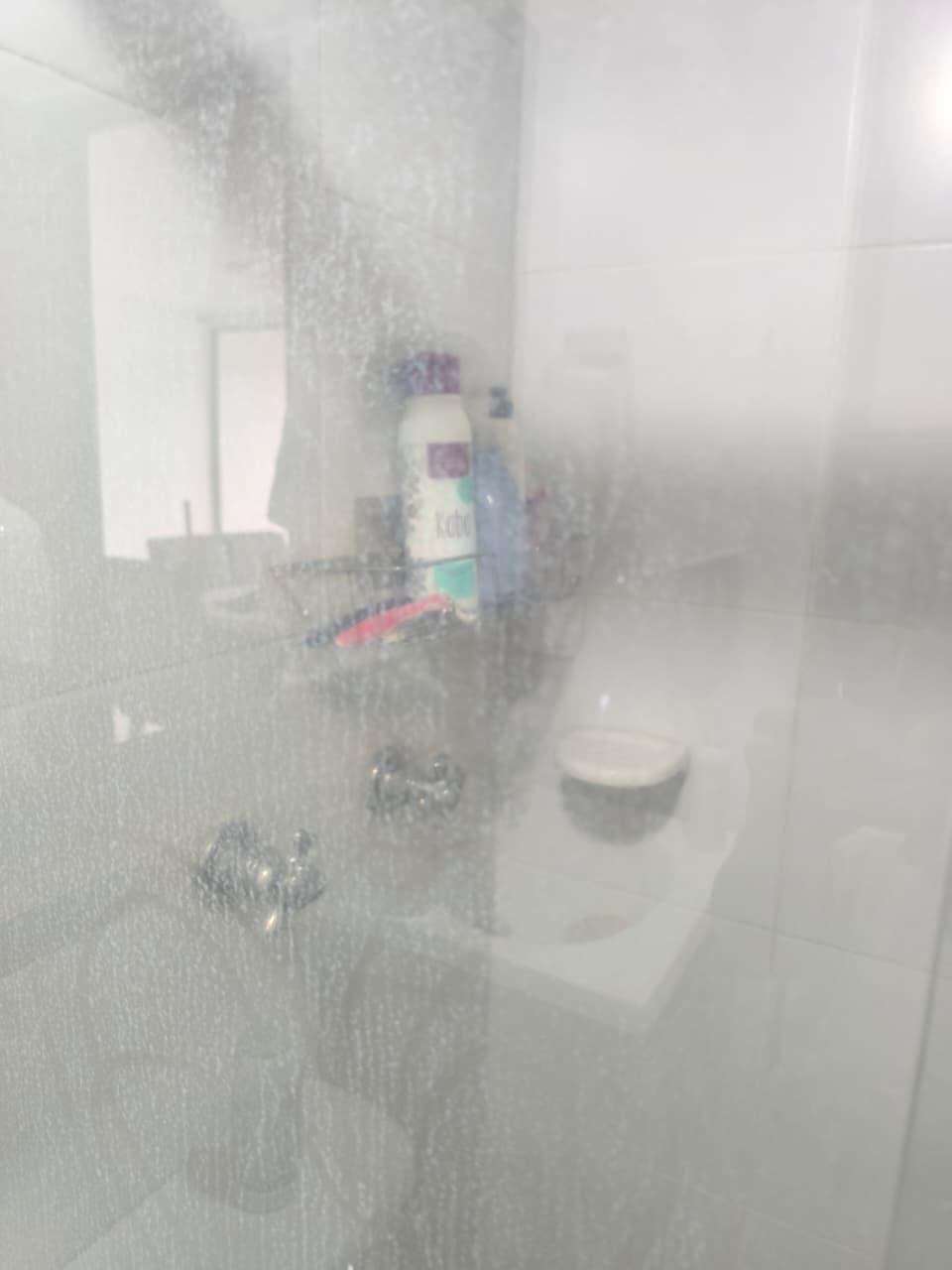 Vidrio de baño con manchas de gota seca antes del tratamiento